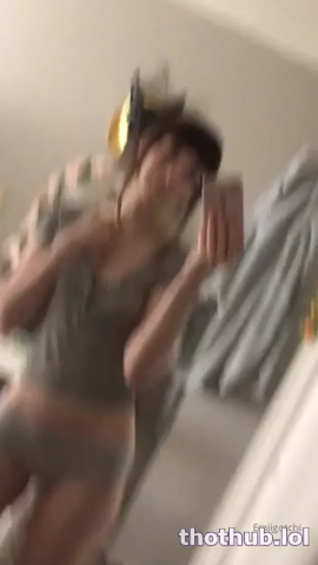 Emi admires herself in the mirror