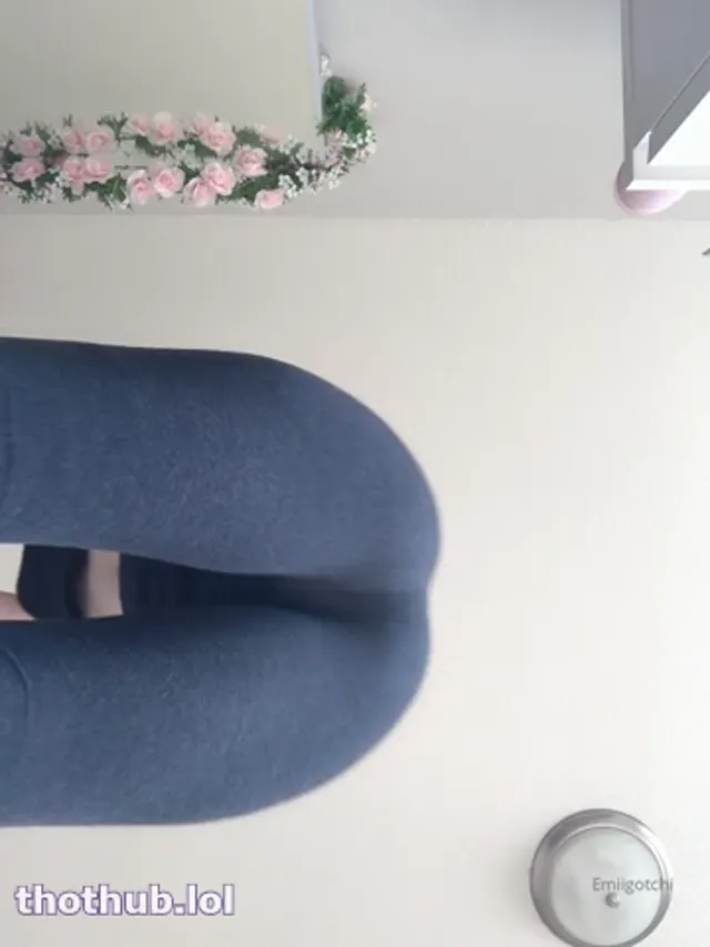 Emi squats in yoga suit over camera